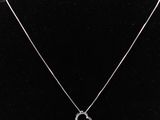 un collier en argent avec un pendentif en forme de cœur sur un mannequin noir