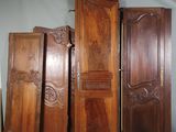 Plusieurs portes en bois sont alignées contre un mur dans une pièce