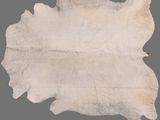 un tapis en peau de mouton blanche sur fond gris