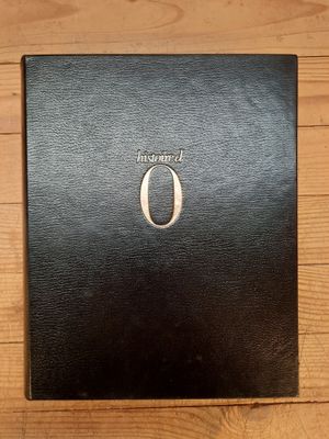 un gros plan sur un livre noir posé sur une table en bois