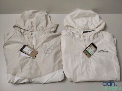 deux vestes blanches, encore étiquetées, posées sur une table