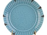 assiette bleue et blanche avec un pied doré sur fond blanc