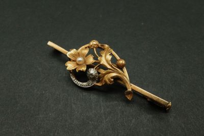 un gros plan d'une broche ornée de fleurs
