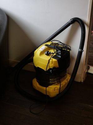 un aspirateur jaune et noir posé par terre à côté d'une chaise noire