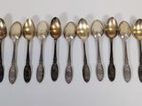 six spoons are lined up in a row on a white surface