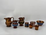 un ensemble d'objets en verre de différentes couleurs posés sur une surface blanche