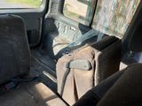 un siège à l'arrière d'une camionnette, sur lequel est posé un sac