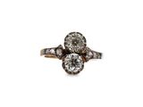 a close up of a diamond and gold ring on a white background