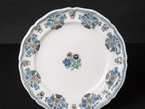 a close up of a blue and white plate with flowers on it