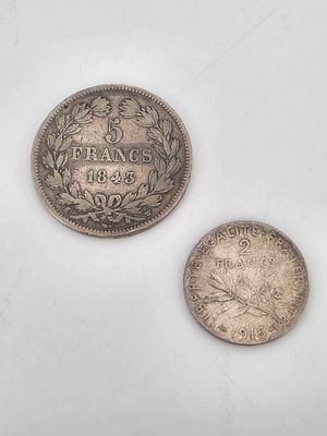 two silver coins sitting next to each other on a white surface