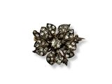 un gros plan d'une broche en forme de fleur sur fond blanc