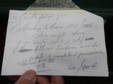 une main tenant un bout de papier sur lequel est écrit quelque chose