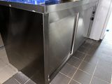 un îlot de cuisine en acier inoxydable avec un plan de travail bleu