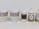 quatre tasses et récipients différents posés sur une surface blanche