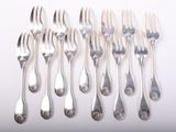 six forks and six spoons arranged in a row on a white surface
