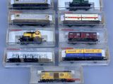 several different types of train cars in plastic containers on a blue surface
