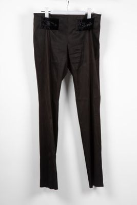 un pantalon noir suspendu à un cintre devant un mur blanc
