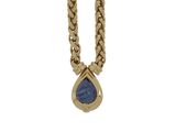 a close up of a necklace with a blue stone on it