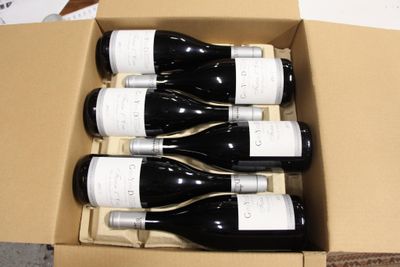 six bouteilles de vin dans un carton sur une table