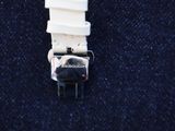 a close up of a white watch on a blue cloth