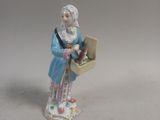 a figurine of a woman holding a basket of flowers