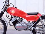 a red motorcycle parked in front of a white wall