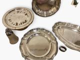 three silver plates and a silver pepper shaker on the table