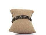 un oreiller marron orné d'une ceinture en cuir noir, sur fond blanc