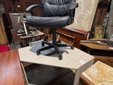 une chaise de bureau noire posée sur une table en bois