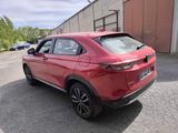the rear end of a red car parked in front of a building