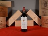 une bouteille de vin posée sur une table à côté de caisses en bois