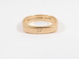 a close up of a gold ring on a white surface