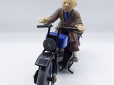 toy figurine of a man riding a motorcycle on a white surface
