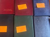 plusieurs livres de couleurs différentes sont alignés sur une table