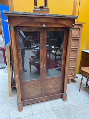 a wooden cabinet with glass doors in the middle of a room