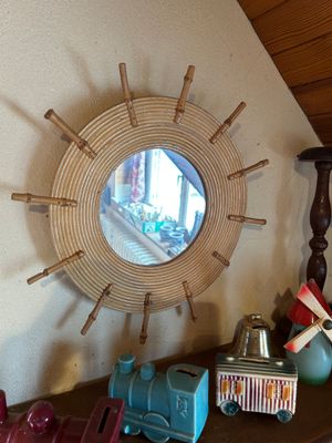 un miroir accroché au mur au-dessus d'une étagère sur laquelle se trouve un petit train miniature