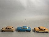 three toy cars sitting next to each other on a table
