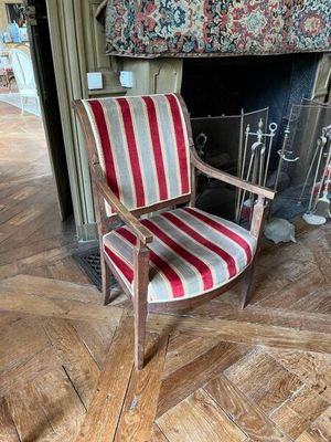 une chaise rayée rouge et blanche placée devant une cheminée