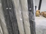 de nombreux rouleaux de tissu posés à même le sol dans un entrepôt