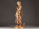 an antique bronze statue of a woman holding a flower