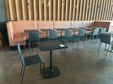 de nombreuses tables et chaises dans un restaurant, avec un mur derrière elles