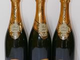 three bottles of champagne sitting next to each other on a table