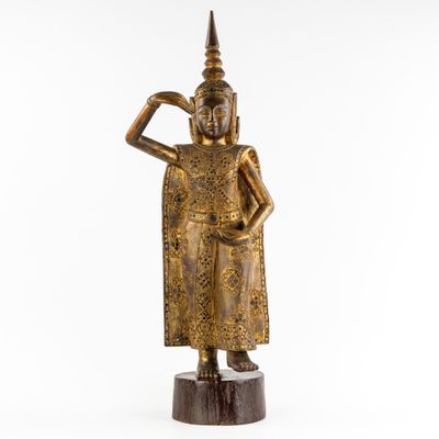 une statue en bronze représentant une personne portant un chapeau sur la tête