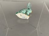 figurine of a bird in a clear box on a table