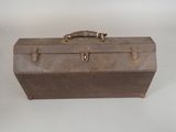 an old suitcase sitting on a table with a handle