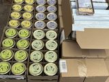 Des cartons de conserves sont empilés sur une palette dans un entrepôt