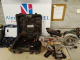 une mallette à outils contenant des outils, posée par terre à côté d'une boîte
