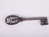 a close up of an old key on a white surface