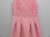 a pink dress hanging on a wall with a white wall in the background