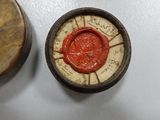 two wooden boxes with wax seal on them sitting on a table